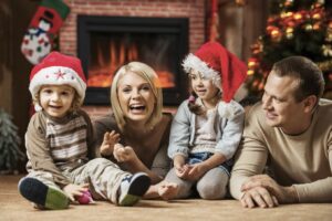 Happy parents with their two little children celebrating Christmas at home.  [url=http://www.istockphoto.com/search/lightbox/9786778][img]http://dl.dropbox.com/u/40117171/family.jpg[/img][/url]